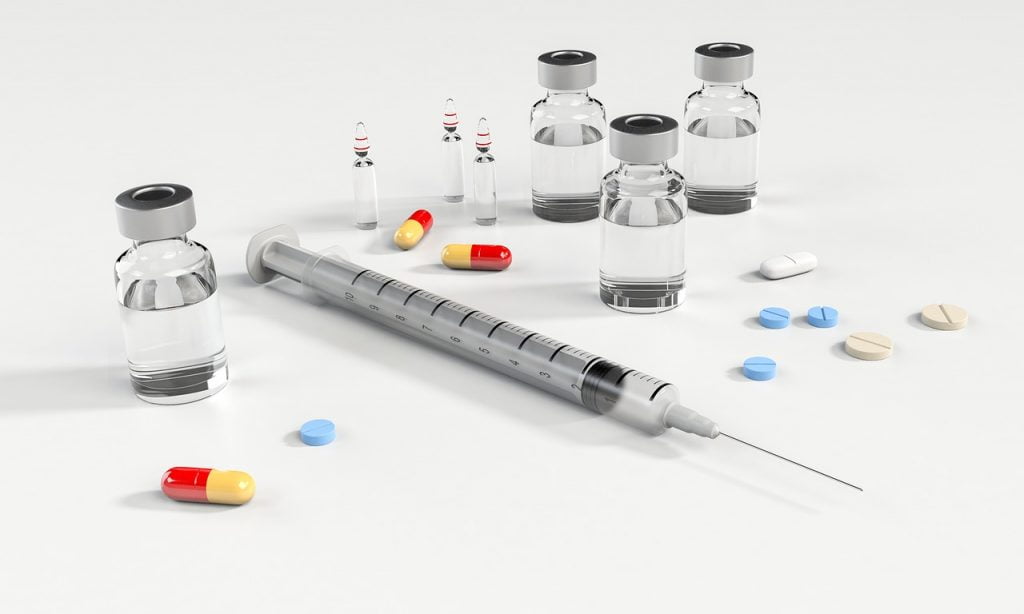 a syringe with liquid and pills