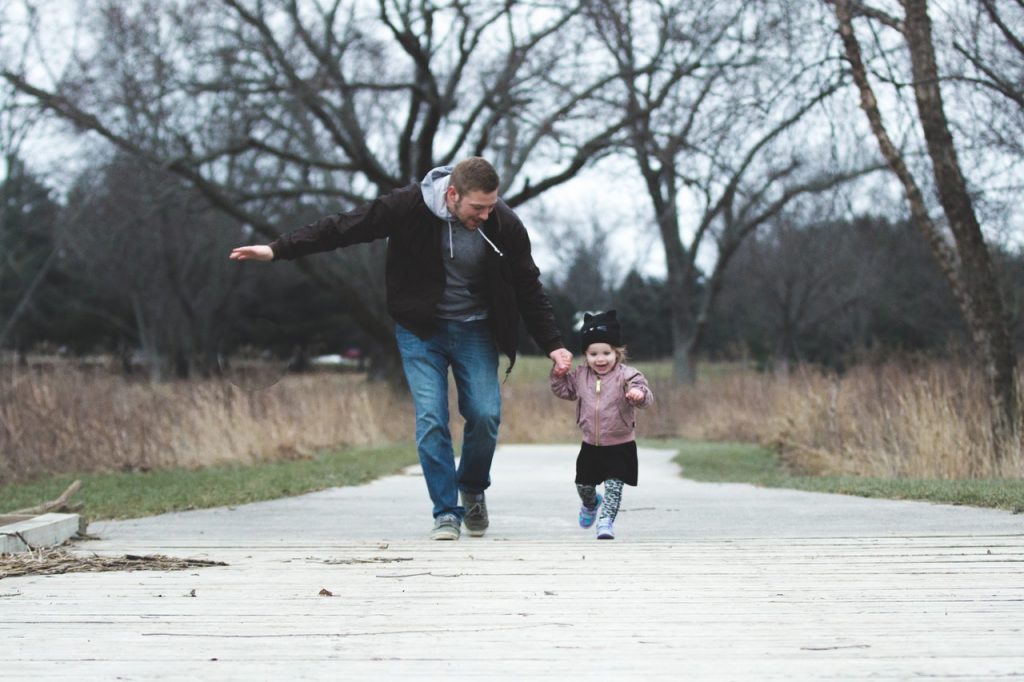 a man and a child walking on a road