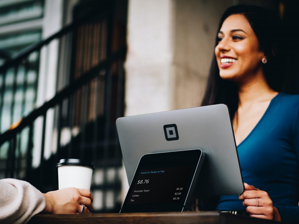 a woman smiling at a laptop