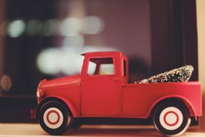 a red truck with a large load of hay on the back