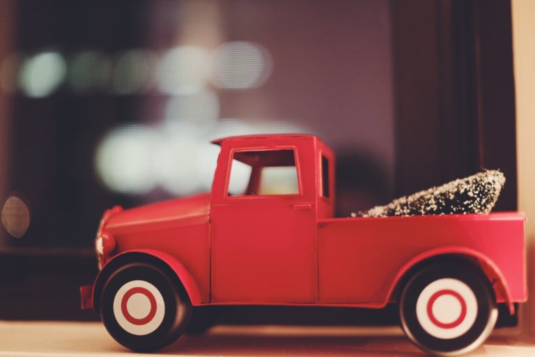 a red truck with a large load of hay on the back