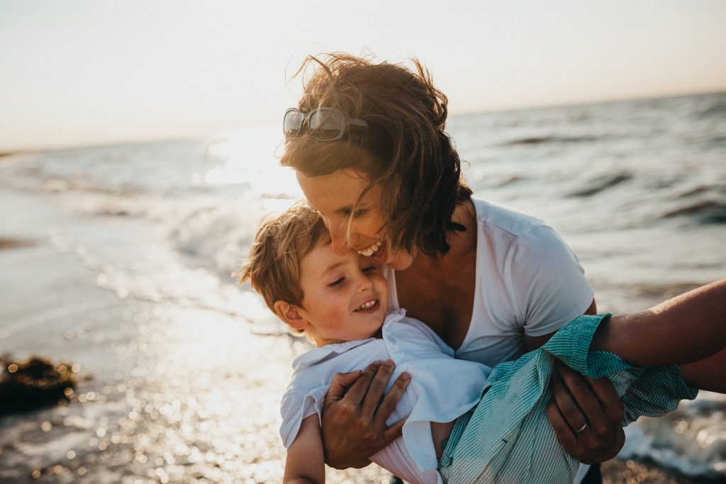 a man and a woman holding a baby on a beach