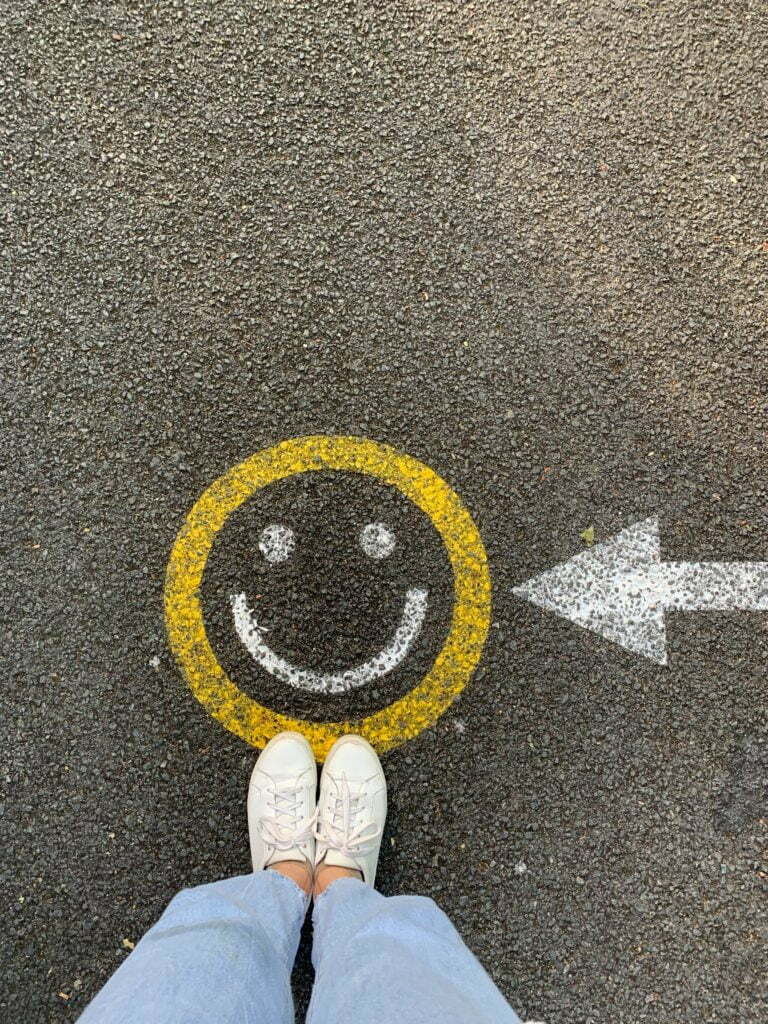 a person's feet and a sign on a road