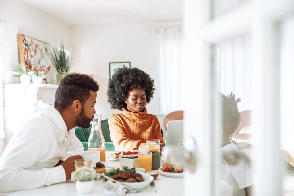 a man and a woman sitting at a table with food