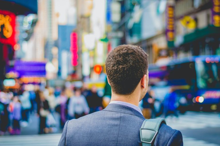 a man in a suit walking down a street