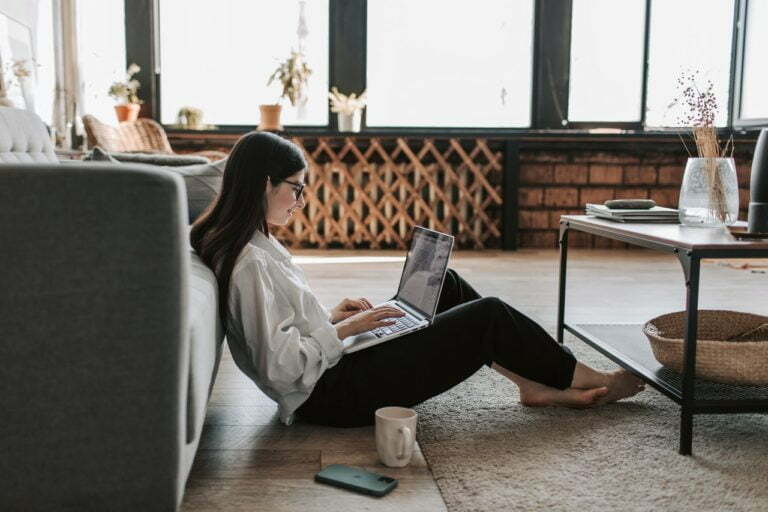 a person sitting on a couch using a laptop