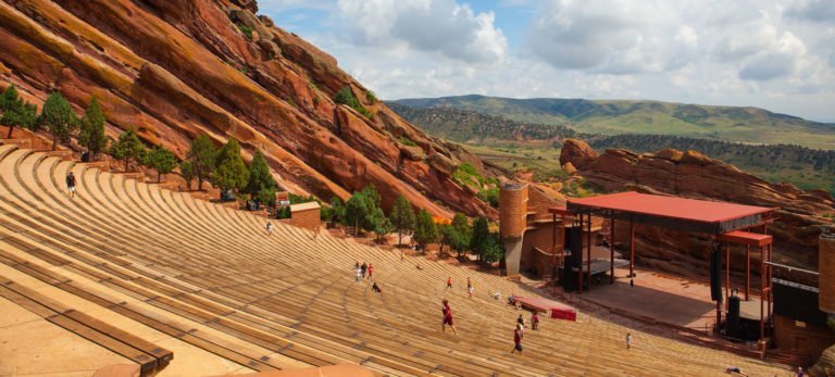 a high angle view of a construction site with Red Rocks Amphitheatre in the background
