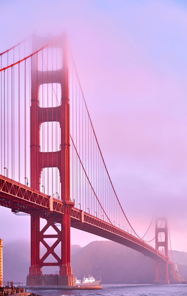 a red bridge with a foggy sky