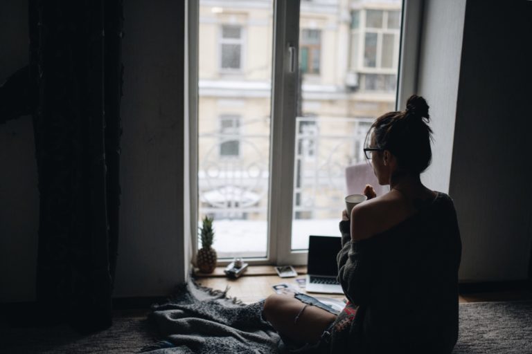 a person sitting on the floor looking at a laptop