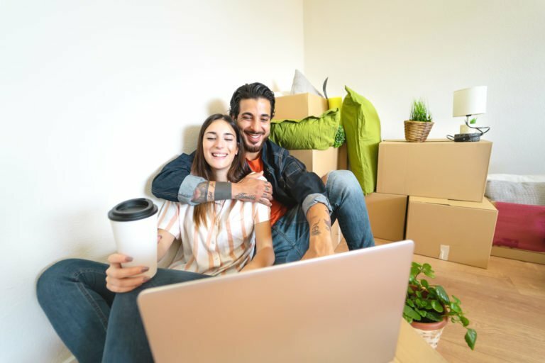 a man and woman sitting on a couch with a laptop