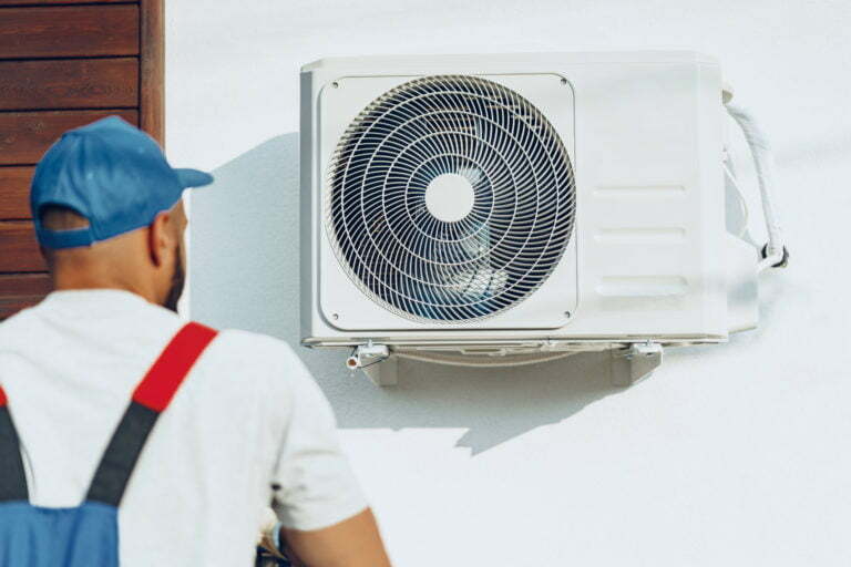 a man wearing a hard hat and looking at a machine