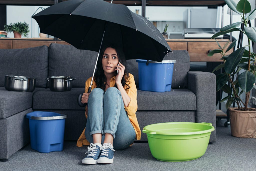 a woman sitting on a couch under an umbrella