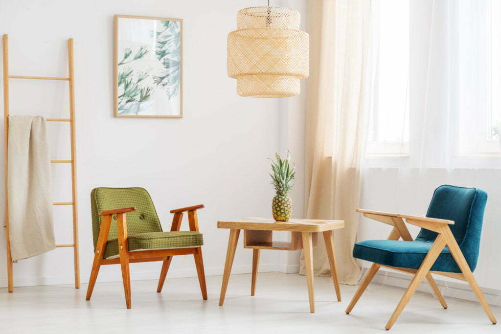 Pineapple on classic table between blue and green chair in simple living room with ladder