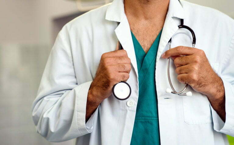 Doctor holding stethoscope in hospital. Healthcare workers, coronavirus and insurance concept