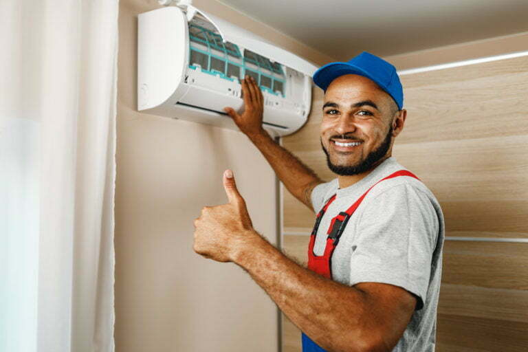 Professional repairman installing air conditioner in a room