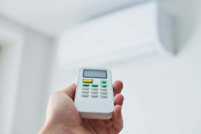 Air condition remote control. Hand with room conditioner remote control. Air temperature switch for cooling of space.