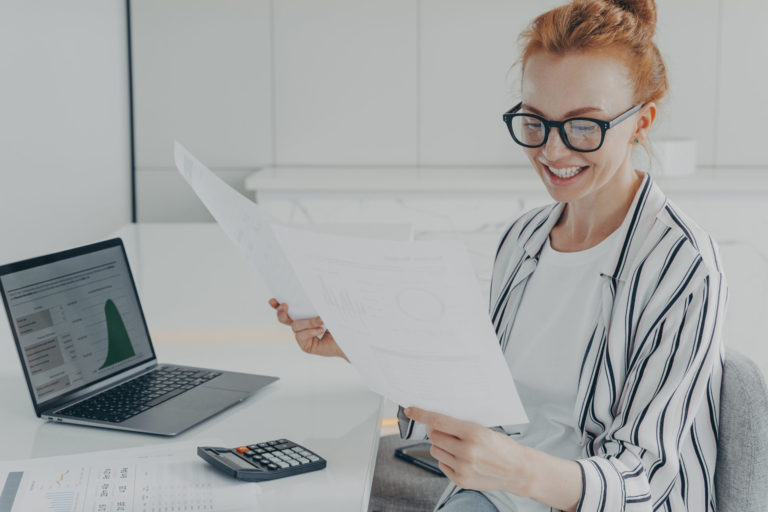 female financier studies financial graphs diagrams counts expenses holds papers