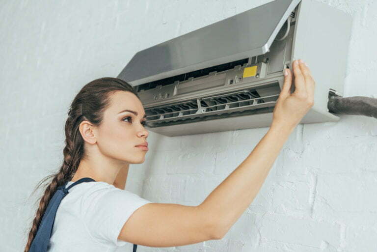 beautiful female worker repairing air conditioner