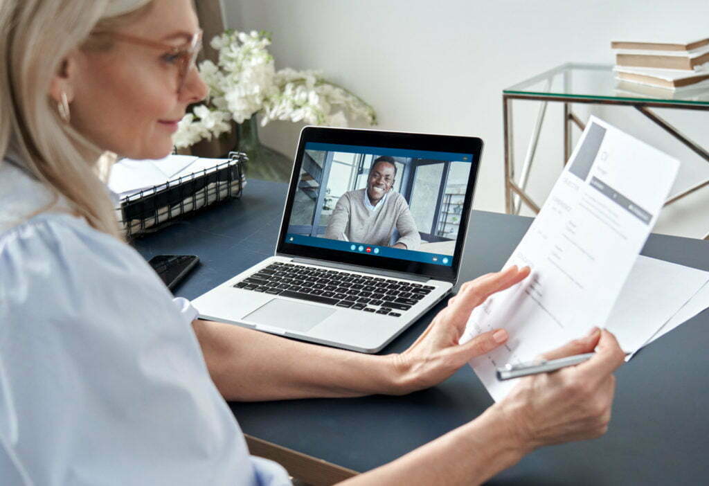 Female hr reading cv during online virtual job interview by video call.