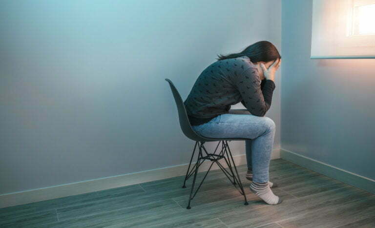 Worried woman with mental health problem sitting on a chair