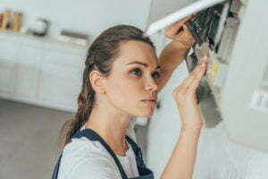 female worker repairing air conditioner